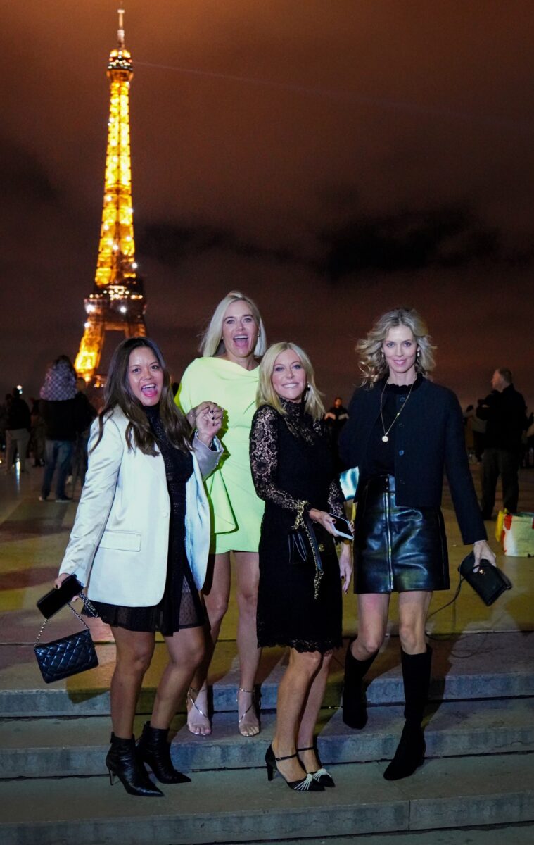Four women in Paris posing for photo in front of Eiffel tower